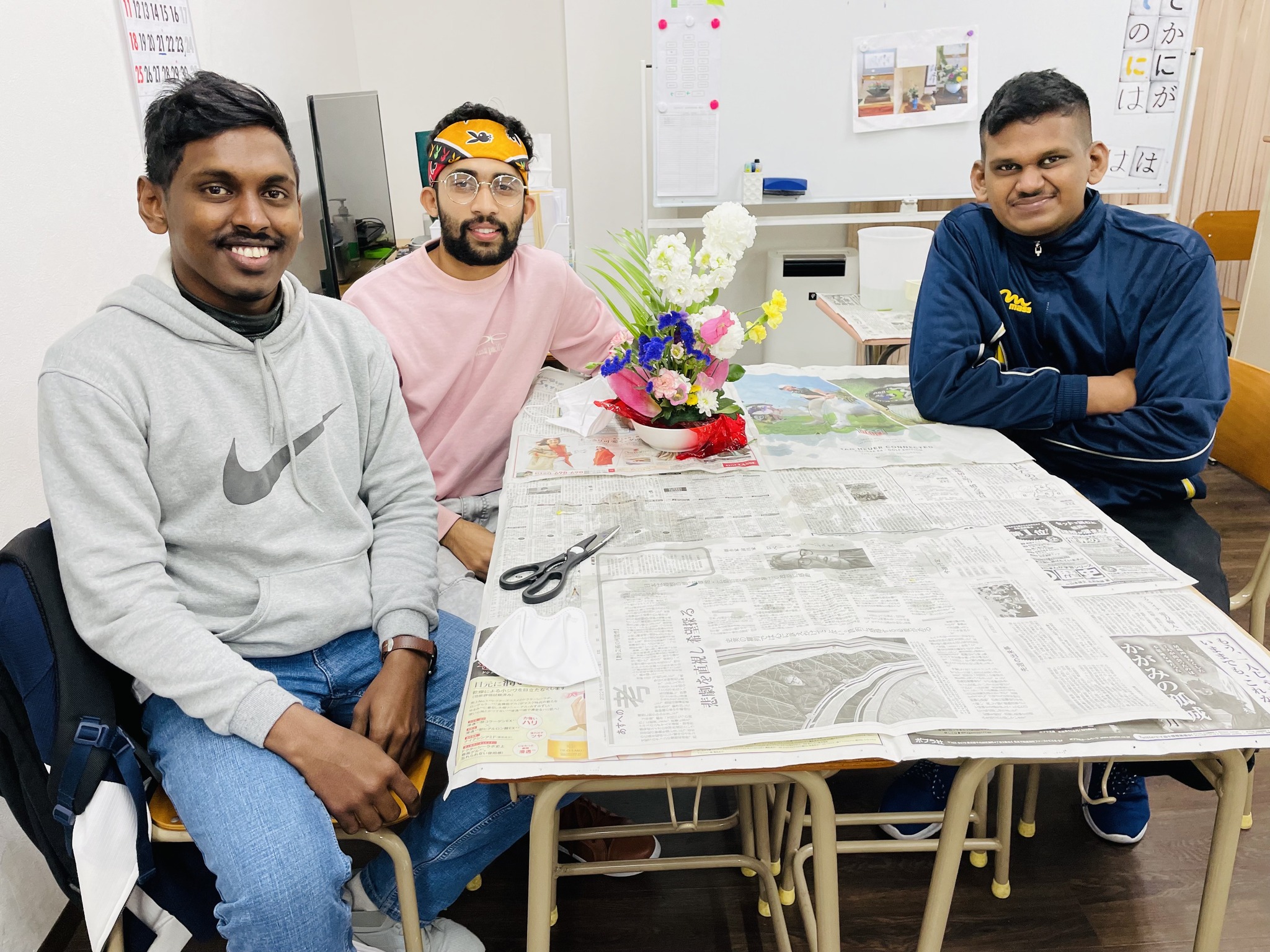 笑顔の学生と生け花