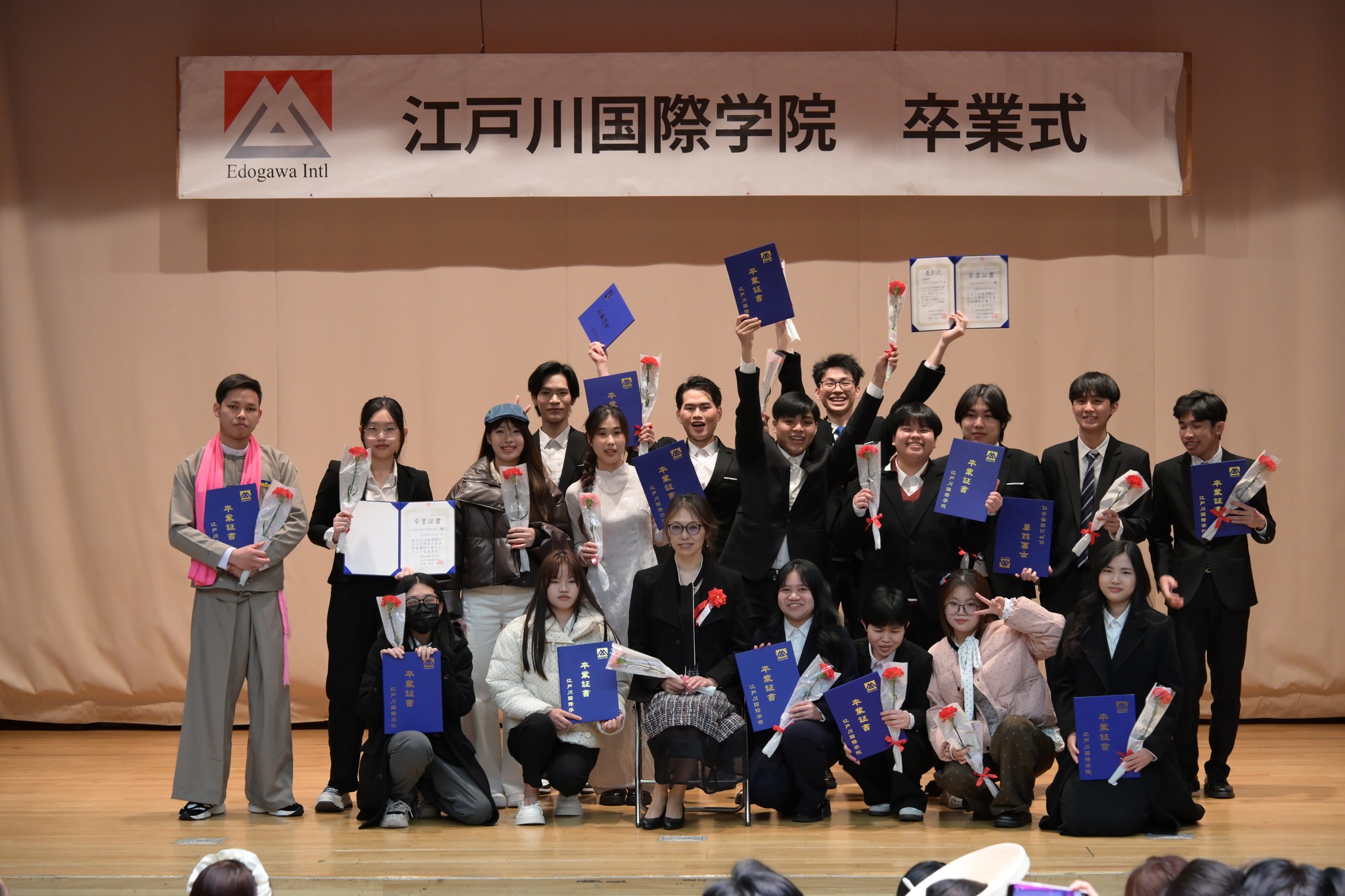 卒業証書を掲げる学生たち